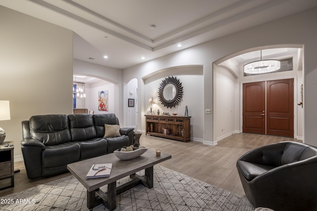 living room with a notable chandelier and light wood-type flooring