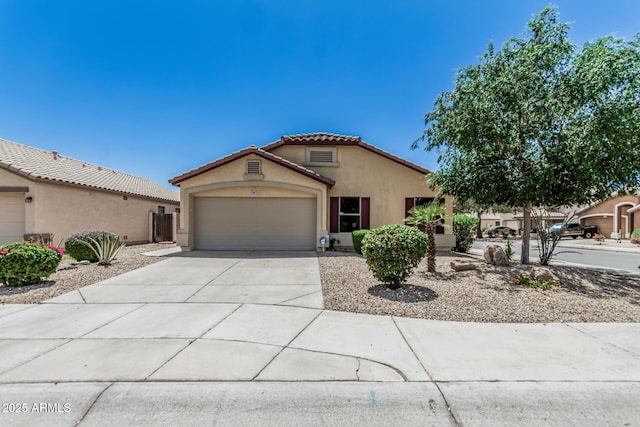 mediterranean / spanish-style house featuring an attached garage, stucco siding, a tiled roof, and concrete driveway