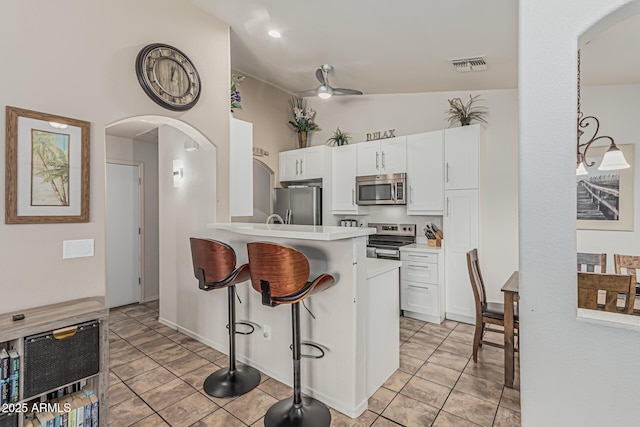kitchen with visible vents, white cabinetry, a kitchen bar, and stainless steel appliances