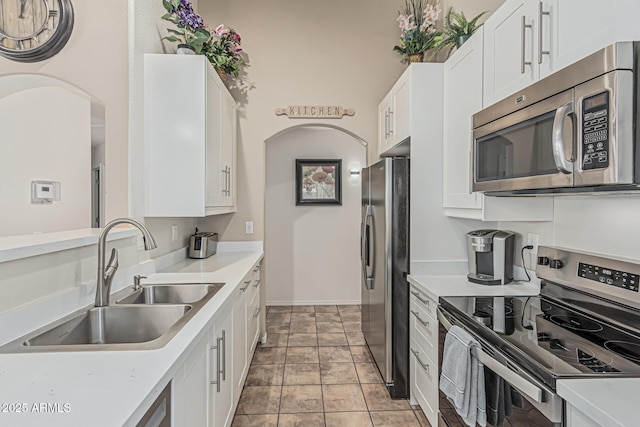 kitchen featuring a sink, light countertops, white cabinets, and stainless steel appliances