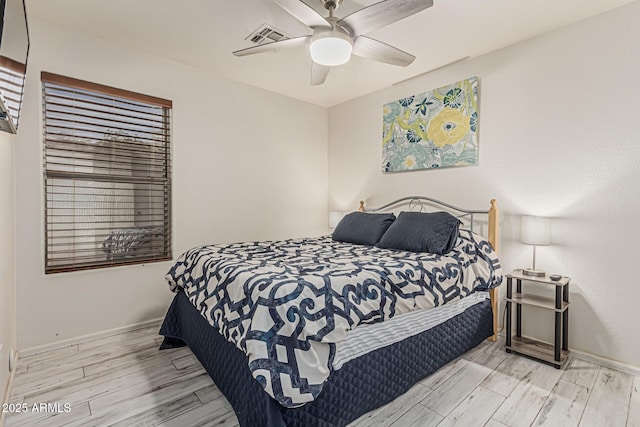 bedroom featuring ceiling fan, baseboards, visible vents, and wood finished floors