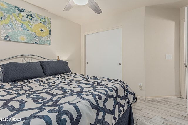 bedroom with a ceiling fan, baseboards, and light wood finished floors