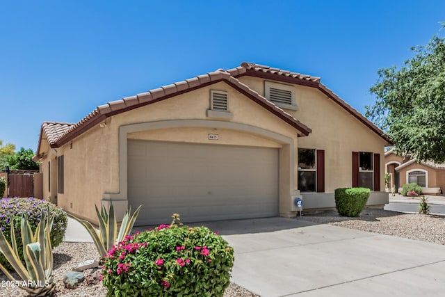 mediterranean / spanish-style home with a garage, stucco siding, and a tile roof