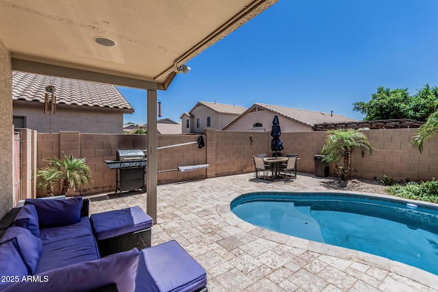 view of pool with a fenced in pool, a fenced backyard, a patio area, and area for grilling