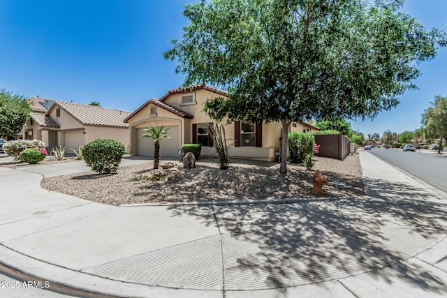 mediterranean / spanish-style home with an attached garage, stucco siding, driveway, and a tile roof