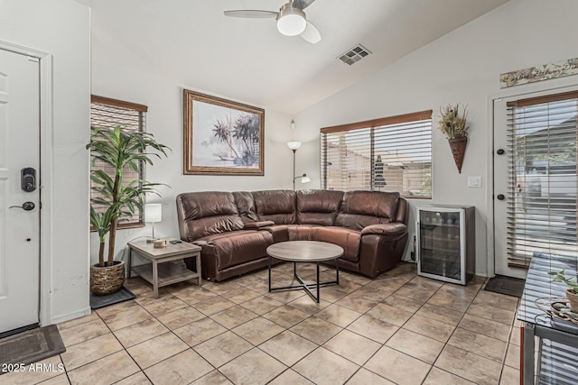 living area featuring ceiling fan, a healthy amount of sunlight, vaulted ceiling, wine cooler, and visible vents