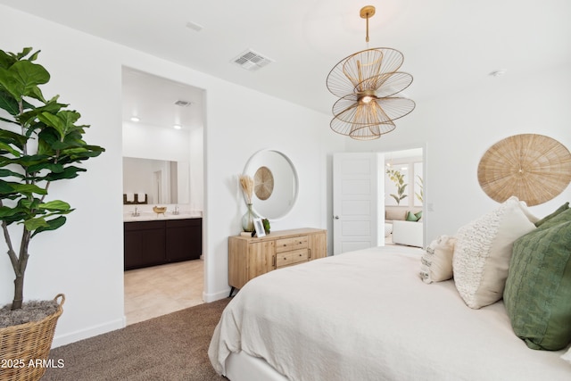 carpeted bedroom featuring connected bathroom and a notable chandelier