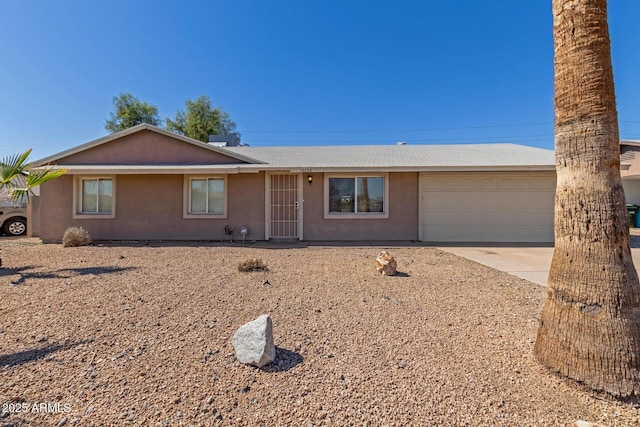 single story home with concrete driveway, an attached garage, and stucco siding