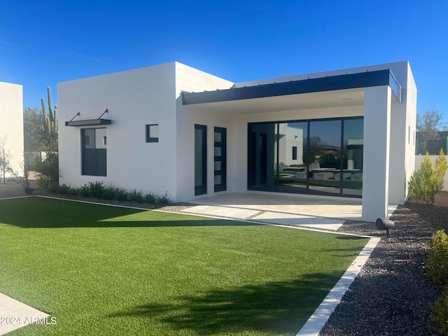 rear view of property with a lawn