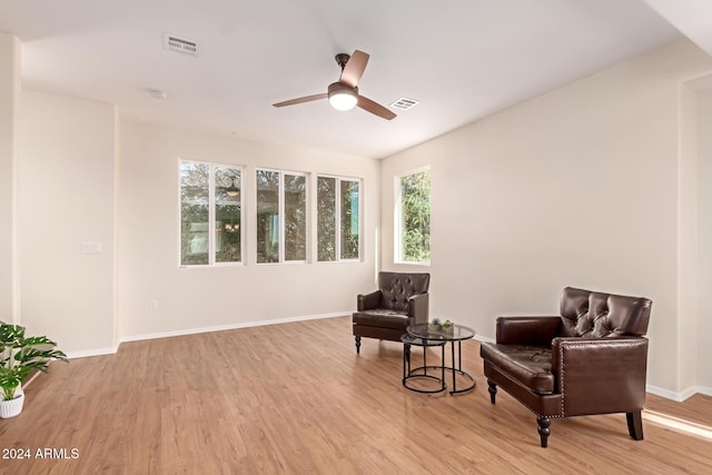 living area with ceiling fan, light wood-type flooring, and a wealth of natural light