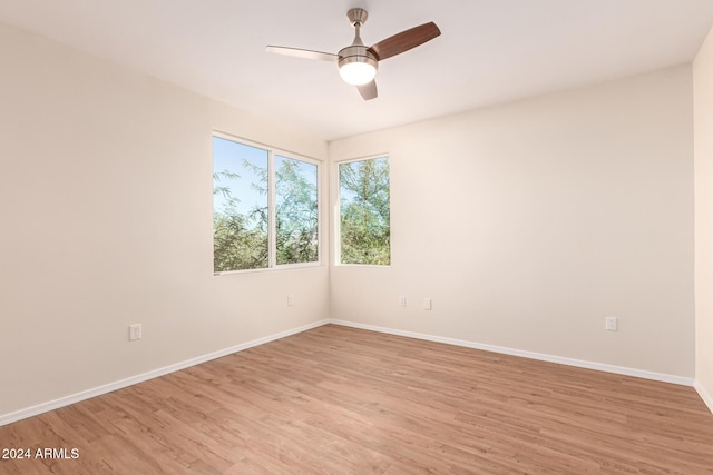 spare room with light wood-type flooring and ceiling fan