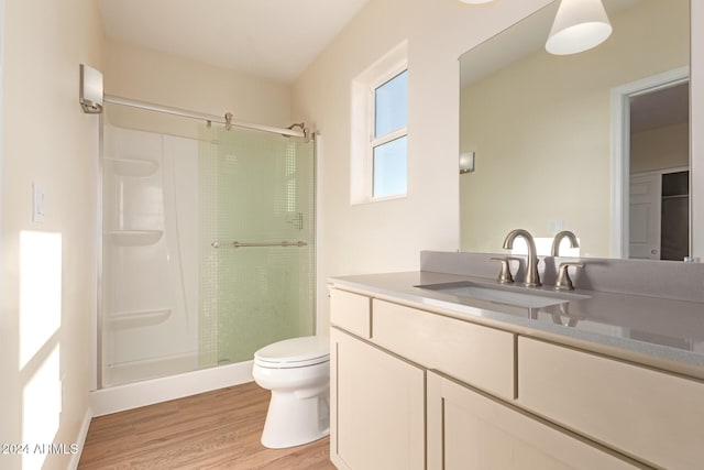 bathroom with vanity, toilet, wood-type flooring, and walk in shower