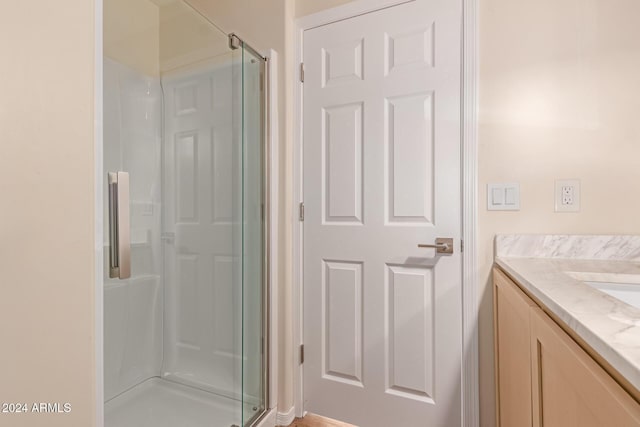 bathroom with vanity and a shower with shower door