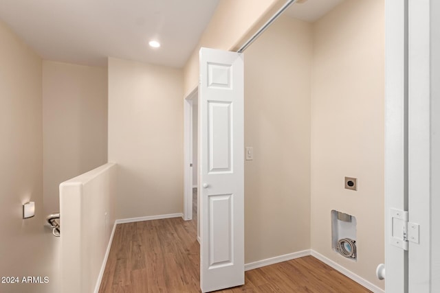 laundry room featuring electric dryer hookup and light hardwood / wood-style flooring