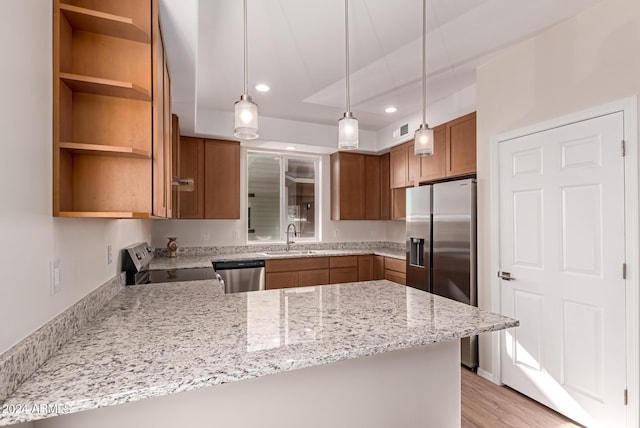 kitchen featuring kitchen peninsula, appliances with stainless steel finishes, light wood-type flooring, light stone counters, and sink