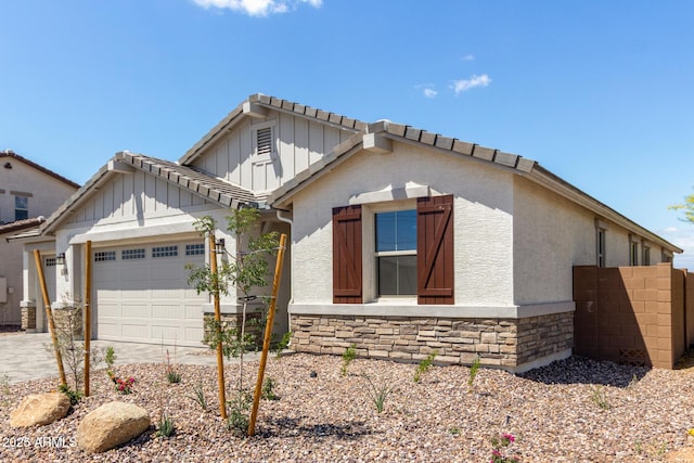 12358 W Marguerite Ave, Avondale, AZ 85323 - view of front of house with driveway, stone siding, board and batten siding, an attached garage, and stucco siding