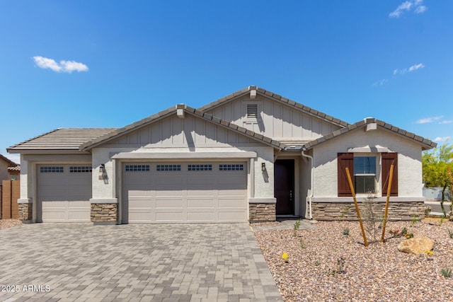 12358 W Marguerite Ave, Avondale, AZ 85323 - view of front of home with an attached garage, a tile roof, stone siding, and decorative driveway