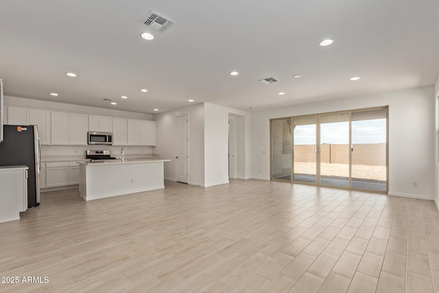 12358 W Marguerite Ave, Avondale, AZ 85323 - unfurnished living room featuring recessed lighting, visible vents, and baseboards