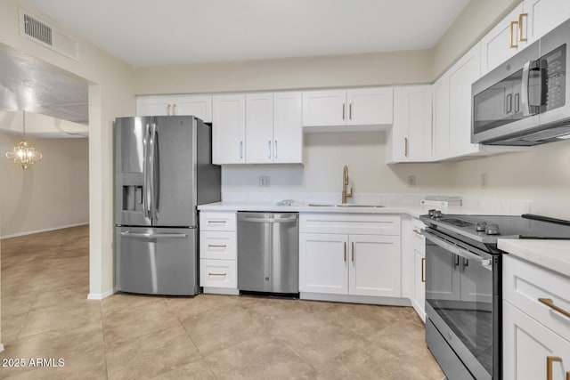 kitchen with sink, a chandelier, white cabinetry, and appliances with stainless steel finishes