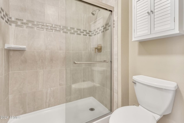 bathroom with an enclosed shower and toilet