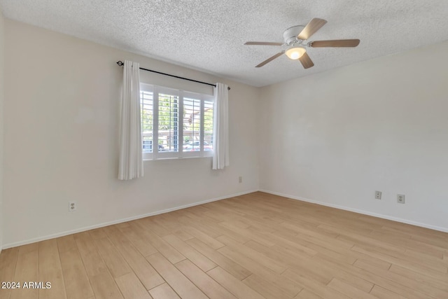 unfurnished room featuring ceiling fan, light hardwood / wood-style flooring, and a textured ceiling