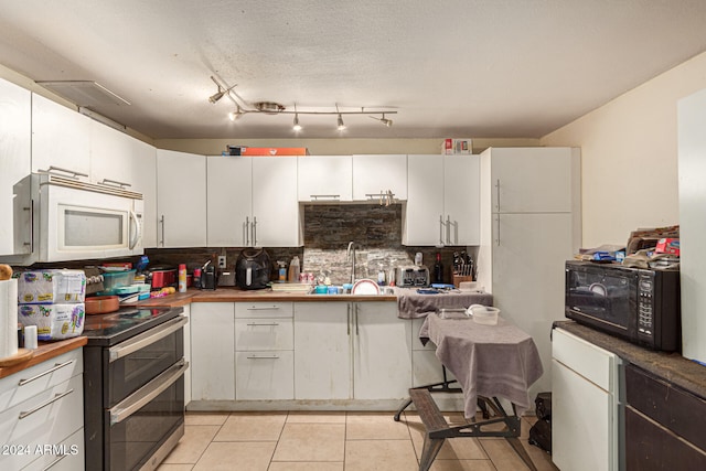 kitchen with sink, backsplash, white cabinetry, and stainless steel electric range