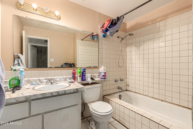 full bathroom featuring vanity, toilet, and tiled shower / bath