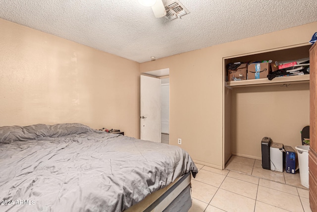 tiled bedroom with a textured ceiling and ceiling fan