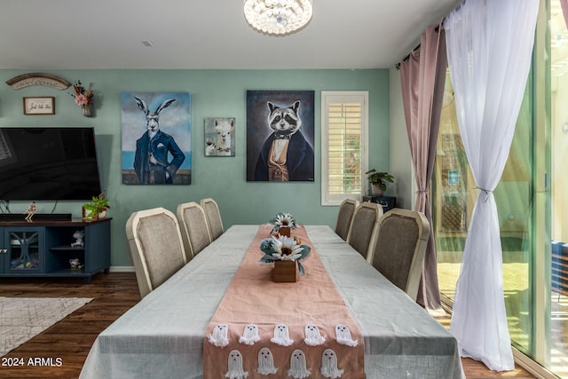 dining area with dark wood-type flooring and a chandelier