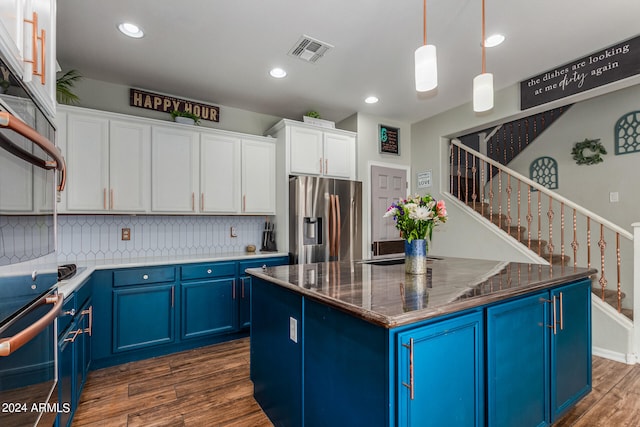 kitchen featuring a center island, stainless steel appliances, dark hardwood / wood-style flooring, and blue cabinetry