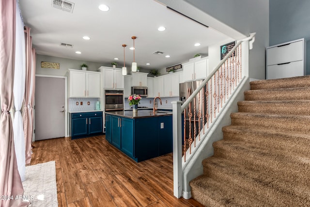 kitchen featuring decorative light fixtures, dark hardwood / wood-style flooring, sink, blue cabinets, and white cabinets