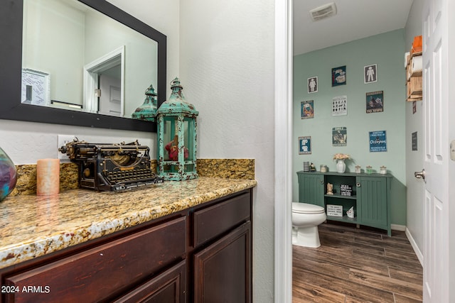 bathroom with toilet, hardwood / wood-style flooring, and vanity