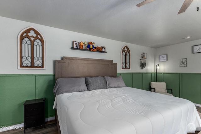 bedroom with ceiling fan, dark hardwood / wood-style flooring, and a textured ceiling