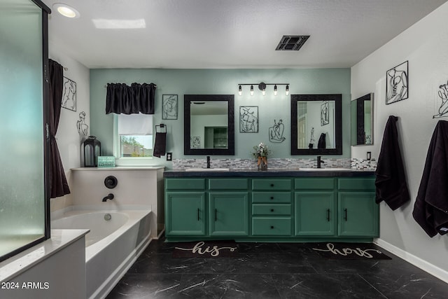 bathroom with vanity, a textured ceiling, and a bathtub