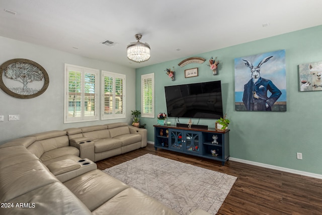 living room featuring dark wood-type flooring and a notable chandelier