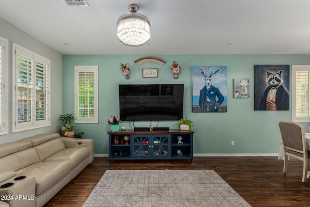 living room featuring a wealth of natural light, a notable chandelier, and dark hardwood / wood-style floors