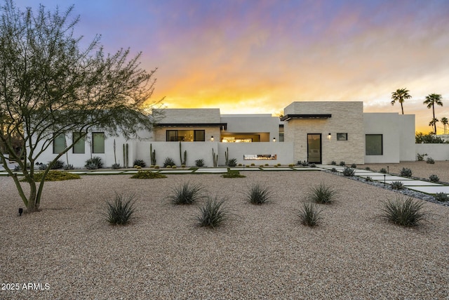 modern home with fence private yard and stucco siding