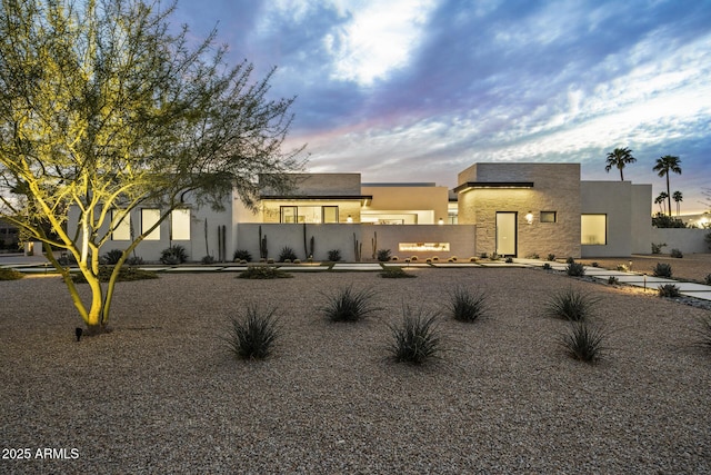 view of front of home featuring fence and stucco siding