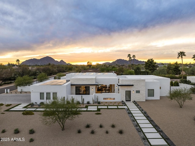 back of house featuring a mountain view and stucco siding