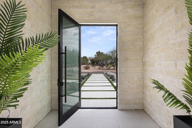 doorway to outside with tile patterned flooring