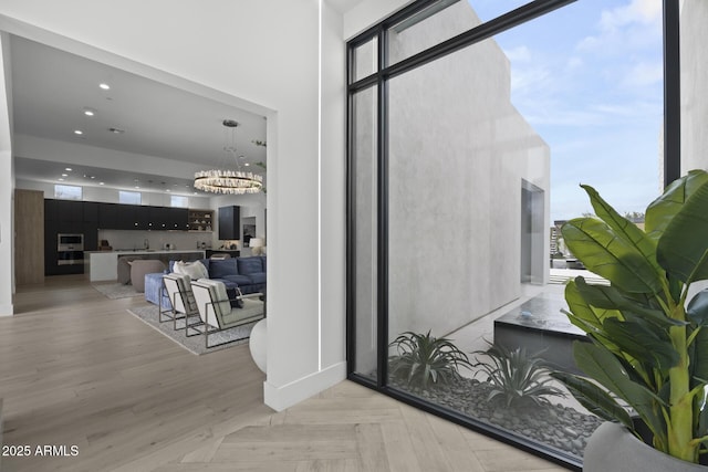 doorway to outside featuring an inviting chandelier, recessed lighting, baseboards, and a healthy amount of sunlight