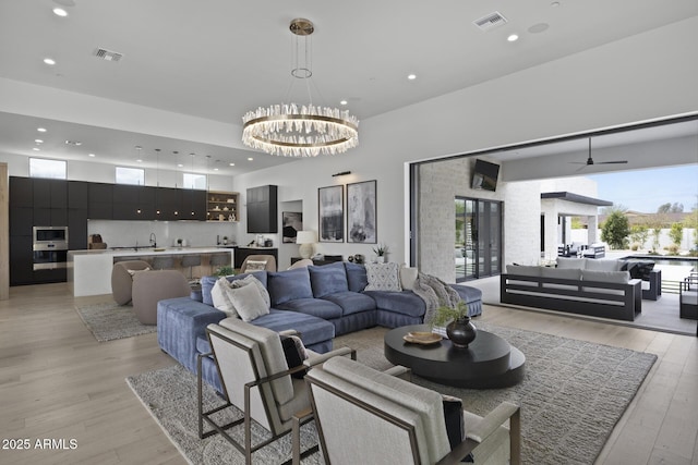 living room with visible vents, recessed lighting, and light wood-style flooring