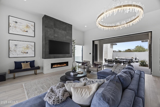 living area with recessed lighting, wood finished floors, and a tile fireplace