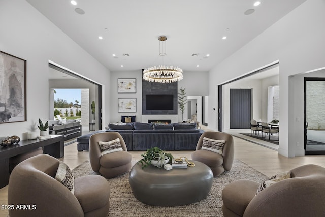 living area with recessed lighting, a notable chandelier, and light wood-style floors