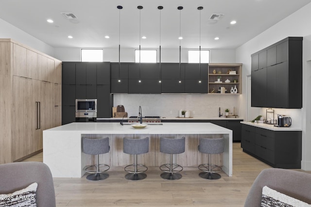 kitchen featuring a kitchen breakfast bar, a sink, appliances with stainless steel finishes, and modern cabinets