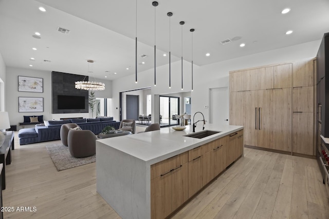kitchen featuring a sink, modern cabinets, visible vents, and light brown cabinets