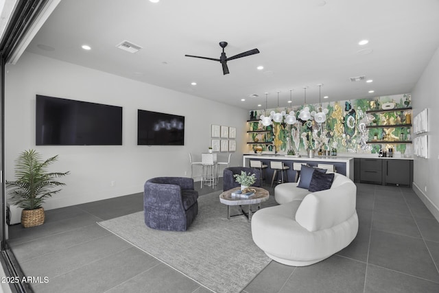 living room featuring a ceiling fan, wet bar, visible vents, dark tile patterned flooring, and recessed lighting