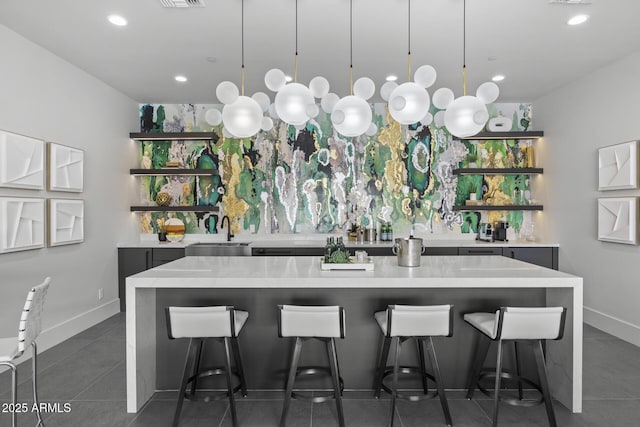 bar featuring a sink, dark tile patterned floors, pendant lighting, and recessed lighting