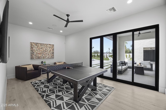 rec room featuring ceiling fan, light wood finished floors, and visible vents