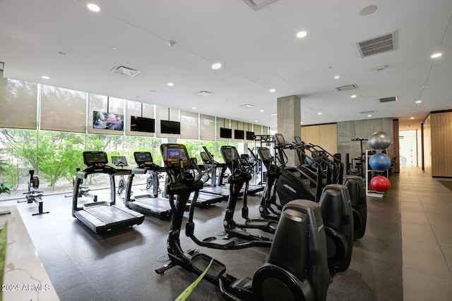 gym featuring floor to ceiling windows and a healthy amount of sunlight